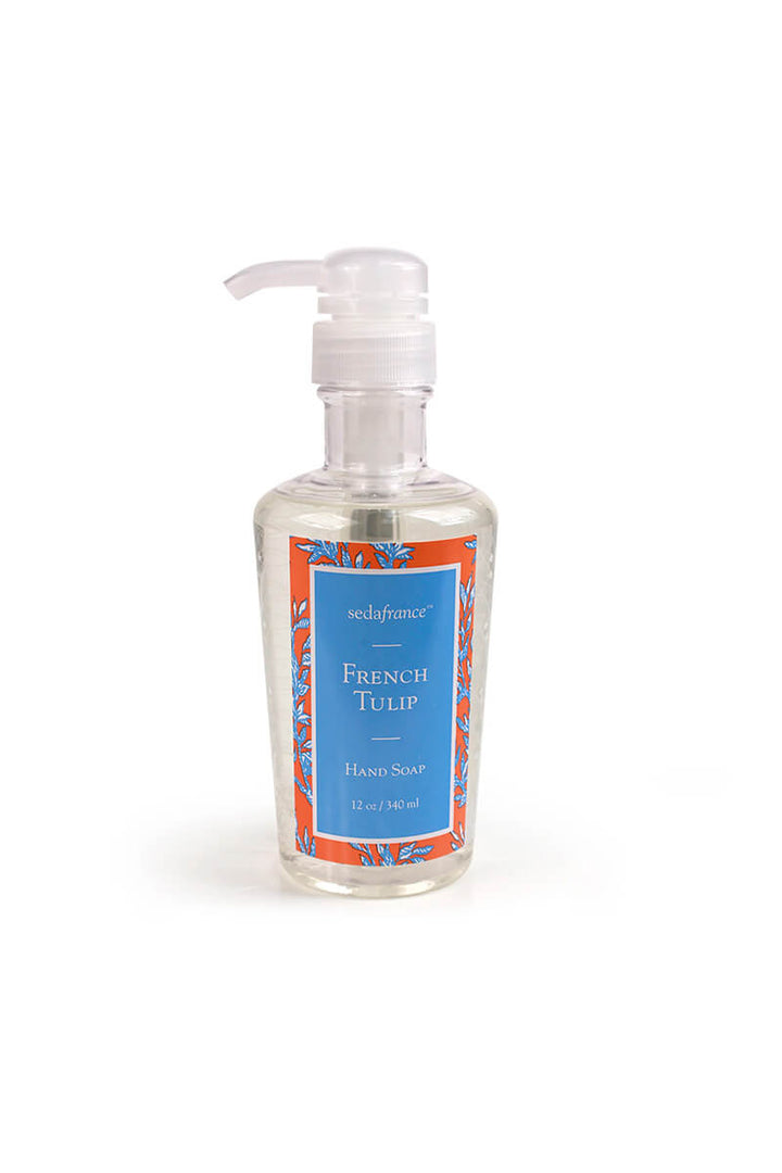 A bottle of SedaFrance French Tulip hand soap with a clear pump dispenser, featuring a blue label with orange and white floral patterns, on a white background.