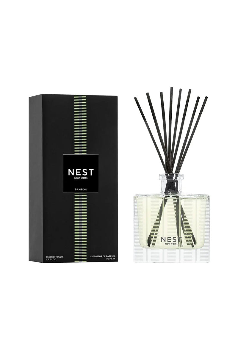 Nest New York Bamboo reed diffuser set, featuring a black rectangular box with green striped accents and a clear glass bottle filled with pale liquid and black reeds, on a white background.