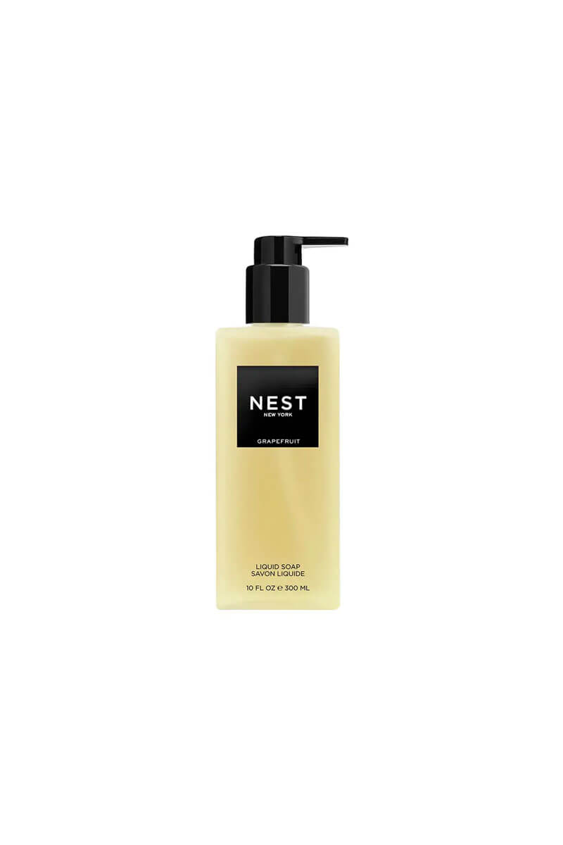 A bottle of NEST Grapefruit Liquid Soap with a black pump dispenser and a pale yellow translucent bottle, centered on a plain white background.