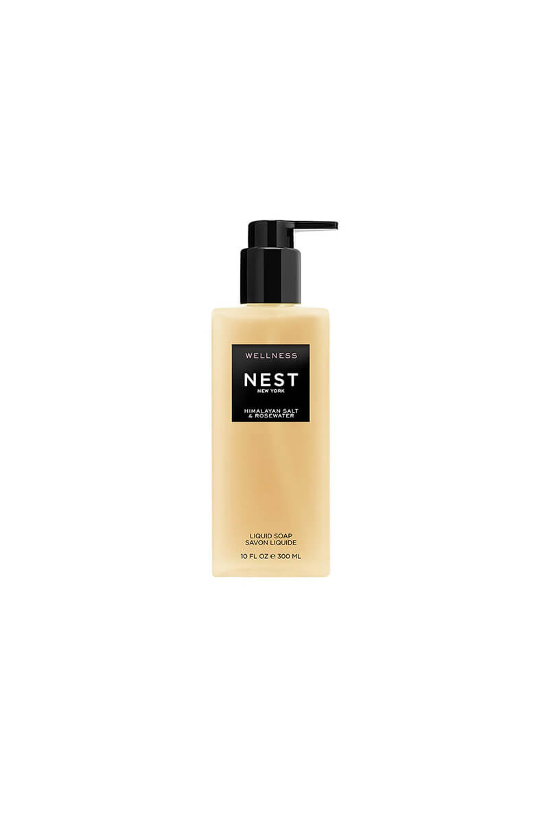 A bottle of NEST Wellness Hand & Foot Soap in the 'Cruelty Free' variant, featuring a beige liquid inside a clear bottle with a black pump dispenser, set against a plain white background.