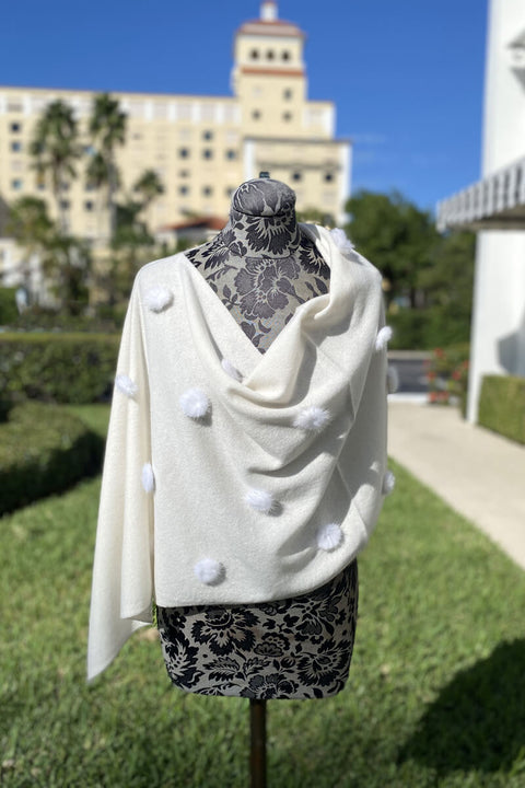 Winter White Poncho with White Pom Detail available at Mildred Hoit in Palm Beach.