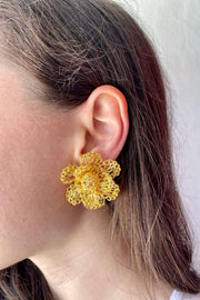 Model wearing Gold Flower Earrings with Crocheted Center available at Mildred Hoit in Palm Beach.