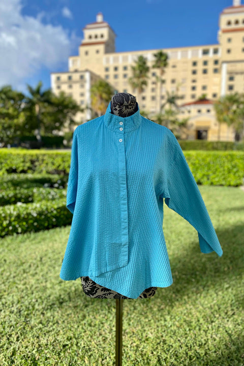 Yacco Maricard Asymmetrical Cotton Blouse in Sky Blouse available at Mildred Hoit in Palm Beach.